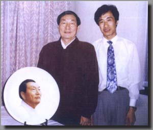 作者与中华人民共和国国务院朱镕基总理，敬刻陶瓷肖像合影留念。